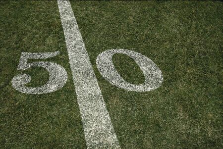 Friday Night Lights Football Game on Football field fifty yard line background. An American football grass turf football field.の写真素材