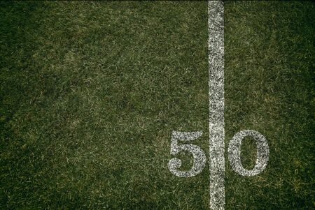 Friday Night Lights Football Game on Football field fifty yard line background. An American football grass turf football field.の写真素材