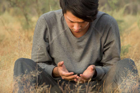 a man praying in a fieldの写真素材