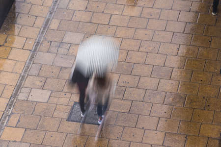 Couple of people walking in a rain in Edinburghの写真素材