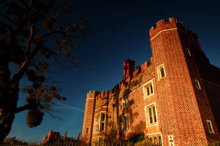 LONDON, circa 2016 - Dramatic shot of the facade of the Hampton Court Palace with the Union Jack in London, England, UK during sunsetのeditorial素材