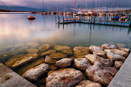 GENEVA, circa 2016 - A wide angle shot of Lake Geneva and marina against a dramatic sky in...