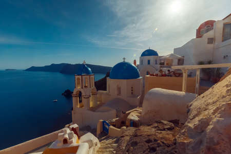 SANTORINI, circa 2015 - Establishing Wide Angle Shot of a Traditional Blue Dome Cycladic Church and the Aegean Sea in Oia, Santorini, Greeceのeditorial素材