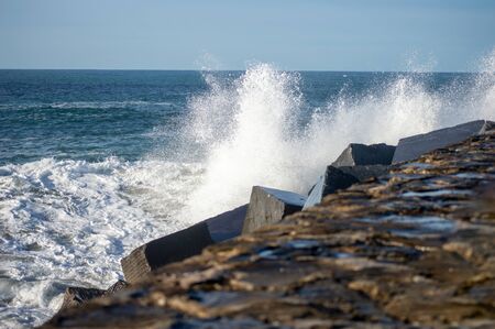 sea water splashing on the breakwater of san sebastian in Spainの写真素材