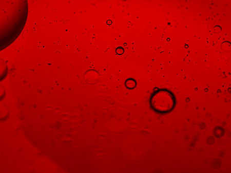 Water drops on a red background. Shallow depth of field.の写真素材