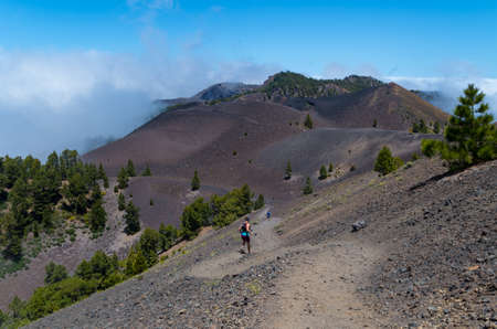 Man and woman running on volcanic path, Ruta de los Volcanes, La Palma, Spainの写真素材