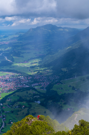 Female mountaineering in the Allgau mountains with townscape of Oberstdorf in the background, Germanyの写真素材