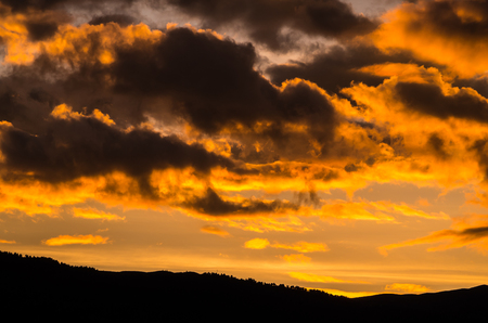 clouded orange sky with mountain silhouette in the dolomites, Val Gardena, Italyの写真素材
