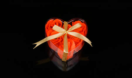 Gift heart with red roses inside with a ribbonの写真素材