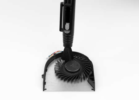 Cleaning the notebook cooler from dust brushの写真素材