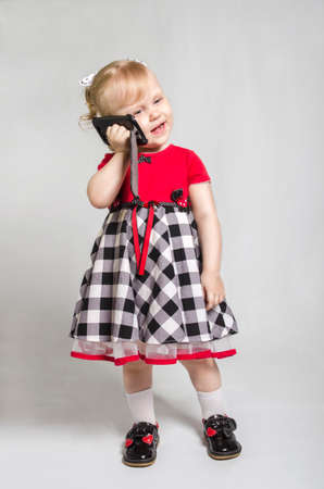 little girl with smartphone look screet photo studioの写真素材