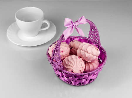 Berry marshmallows in the basket purple with a cup and saucerの写真素材