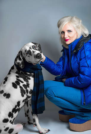 Young blonde girl sitting next to the Dalmatian dogの写真素材