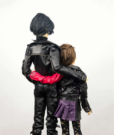 Two articulated dolls hinged man and woman dressed in leather clothing lovers embraceの写真素材