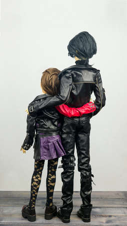 Two articulated dolls hinged man and woman dressed in leather clothing lovers embraceの写真素材