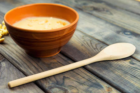 On the table is a wooden background Bowl with soup puree with slices of toast breadの写真素材