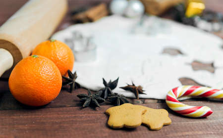 On a wooden desk background Christmas composition - candy cane, dough figurines, Christmas-tree...
