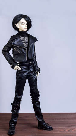 MOSCOW, RUSSIA - November 14, 2015: On a wooden table smiling ball jointed doll male vampire elf in black leather dressの写真素材