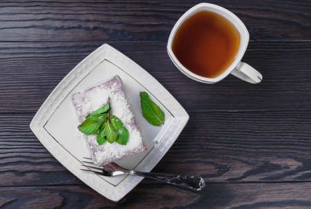 On the dark background wooden table white square plate with a piece of the pie dish pieの写真素材