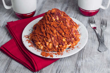 On a light wooden table in vintage style dessert for two cups of white-red, sand cake in the form of slides with cocoa, towel, napkin, forkの写真素材