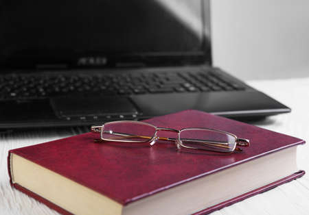 On white wooden background notebook and glasses, bookの写真素材