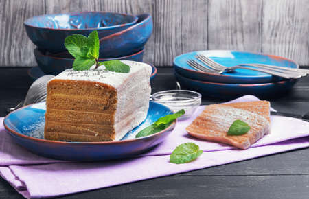 On a dark background black wooden table in the kitchen cooking biscuit cake pie air apple candy, mint leaves, blue ceramic crockeryの写真素材