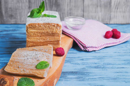 On background blue wooden table in the kitchen biscuit cake pie apple candy pastila, mint leaves, fresh berries raspberries, wood cutting board Oliveの写真素材