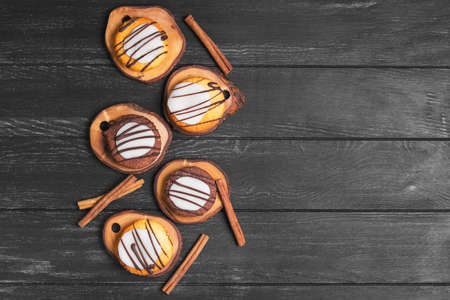 Biscuits, cookies homemade muffins with icing and chocolate, cinnamon sticks on a dark black wooden background, top view, empty place for text, recipeの写真素材