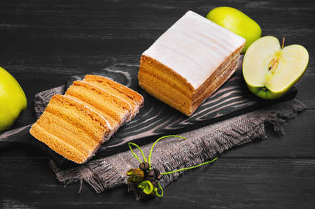 apple biscuit pie pieces, fresh apples, three slices cut biscuit pie on a cutting board on a black wooden background surfaceの写真素材