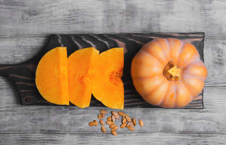 Raw pumpkin pieces cut for baked, pumpkin seeds on bright white background wooden, for Halloween, top viewの写真素材