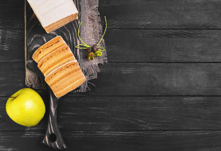 Blank apple biscuit pie, fresh apples, sacking on cutting board, black wooden background surface, empty place for text, top viewの写真素材