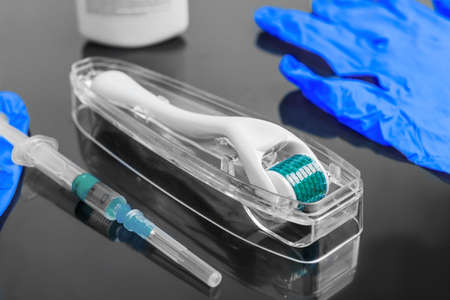 Hyaluronic acid rejuvenation beauty injections. Concept of mesotherapy. Mezoroller, blue gloves, mesotherapy liquid, disposable syringe.の写真素材