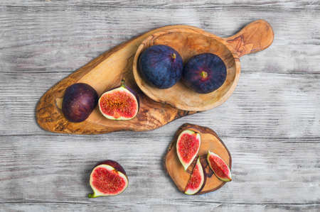Violet Blue figs whole fruit, figs cut into pieces on a board of wood of olive, light white wooden...