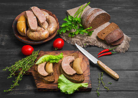 Sandwiches bread with homemade sausage. Loaf rye bread for sandwiches with homemade sausage. Assorted homemade sausage rings. Ingredients for sandwiches sausage thyme, parsley, peppers.の写真素材
