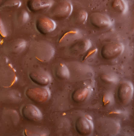 Texture of milk chocolate with nuts. Brown milk chocolate almonds nuts, background. Top view.の写真素材