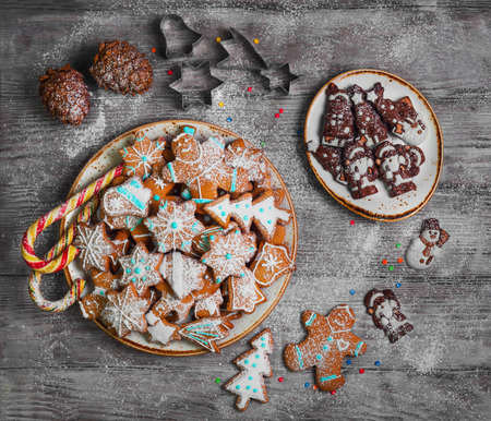 Christmas sweets baking gingerbread cookies on the plate. Forms for Christmas gingerbread cookies, chocolate christmas figurines bumps. Christmas cookies gingerbread on white light table. Top viewの写真素材
