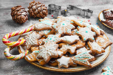 Christmas sweets baking gingerbread cookies on the plate. Forms for Christmas gingerbread cookies, chocolate christmas figurines bumps. Christmas cookies gingerbread on white light table. New Year food.の写真素材