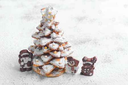 New Year Christmas card. Gingerbread Christmas tree Cookies decorated with icing sugar and sweets. Christmas Chocolate Marzipan figure next to the gingerbread Christmas tree. Sweet snow. Blank spaceの写真素材