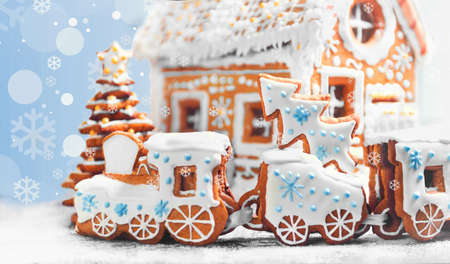 Assorted Christmas gingerbread cookies. Christmas gingerbread village, house, train, tree. Christmas New Year's background with snowflakes. Christmas card with gingerbread village.の写真素材