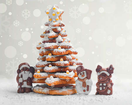 New Year Christmas card. Gingerbread Christmas tree Cookies decorated with icing sugar and sweets. Christmas Chocolate Marzipan figure next to the gingerbread Christmas tree. Sweet snow. Blank spaceの写真素材