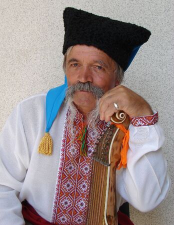Senior ukrainian folk travelling musician bandurist named Kobzar with instrument banduraの写真素材