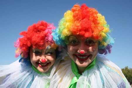 Two bizzare clowns in colored wigs upon blue sky 3
