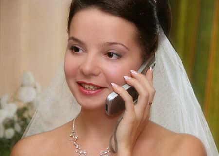 Bride  indoors calling in wedding dayの写真素材