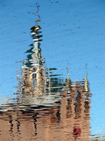 Church Cupola with Holy Cross reflected in wavy water surfaceの写真素材