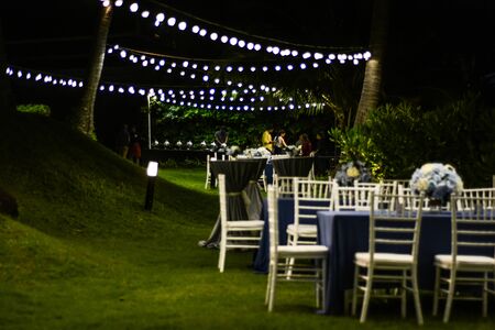 Wedding diner set up on the outside with lights and grassの写真素材