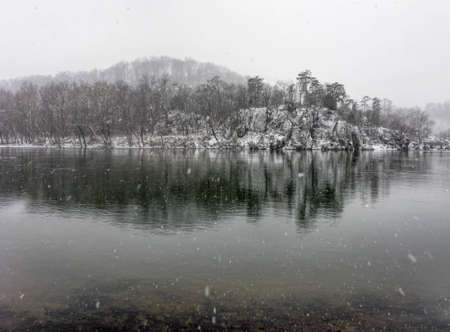 Snowy Reflection on River in Winterの写真素材