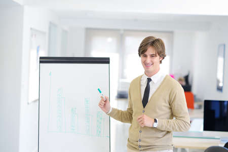 Freelancer looking at his ideas written on paper at modern startup officeの写真素材