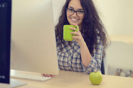 Young businesswoman on a coffee break. Using computer.の写真素材