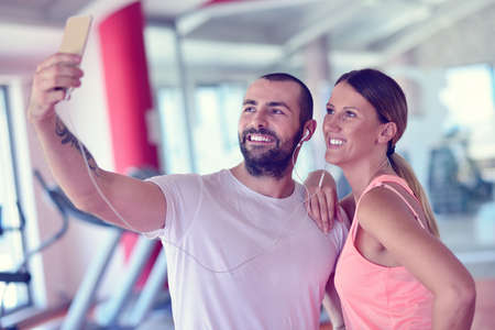 Young couple taking a sefie in a gymの写真素材