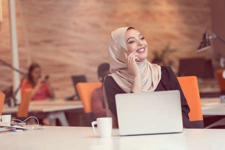 Young Arabic business woman wearing hijab,working in her startup office. Diversity, multiracial conceptの写真素材